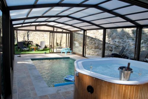 uma piscina com banheira de hidromassagem numa casa em Complejo Casas Rurales MANSIONES Y VILLAS DELUXE em Collado Mediano