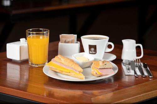 伊基托斯的住宿－Central Bed & Breakfast，夹三明治和咖啡的盘子