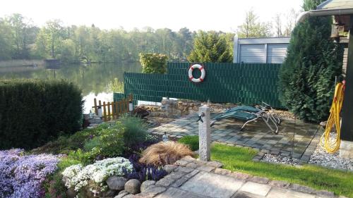 a backyard with a pond and a garden with flowers at KAMA Ferienhäuser Haus Kathrin in Wendisch Rietz