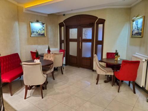 a dining room with red chairs and a table at Edem Hotel Lviv in Lviv