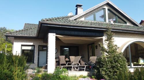a house with chairs on the front porch at KAMA Ferienhäuser Haus Kathrin in Wendisch Rietz