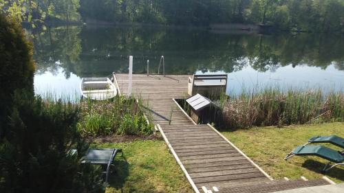a dock on a lake with two boats on it at KAMA Ferienhäuser Haus Kathrin in Wendisch Rietz