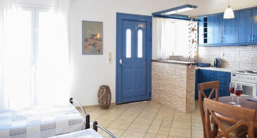 a kitchen with blue cabinets and a blue door at Diana Studios in Trapezaki