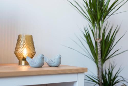 a table with a lamp and two bird figurines on it at Apartment Boavista Roundabout by Sweet Porto in Porto