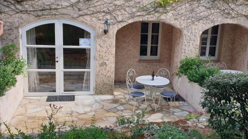 a patio with a table and chairs in a building at Domaine du Bois d'Amont in Cabris