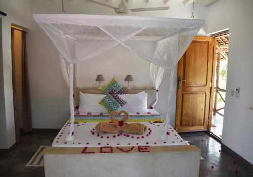 a bedroom with a bed with two pretzels on it at Villa Huruma in Paje