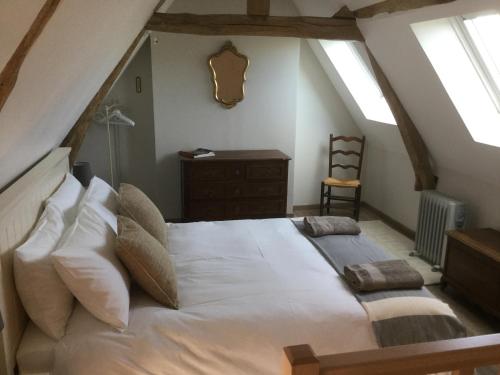 a bedroom with a large white bed in a attic at Maison d Hôtes La Petite Jucherie in Saint-Hippolyte