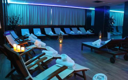 a salon with chairs and tables in a room at Cocca Hotel Royal Thai Spa in Sarnico