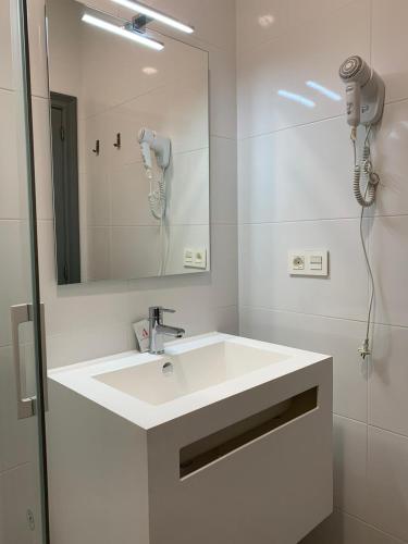 a white bathroom with a sink and a mirror at Alevia in Salamanca