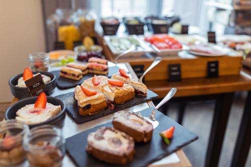 a table topped with different types of food on plates at Hotel Villa Wesset in Pärnu