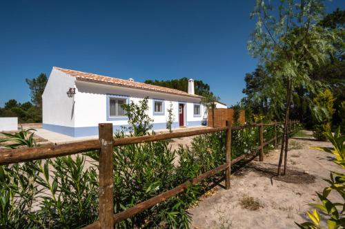 a house on the beach with a fence at Casas da Horta in Alcácer do Sal