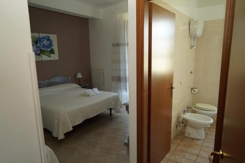 - une petite chambre avec un lit et des toilettes dans l'établissement Agriturismo La Petrosa, à Ceraso