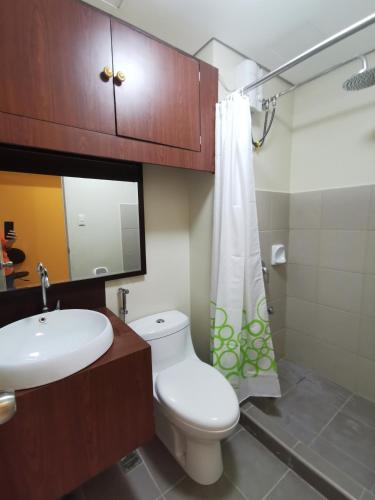 a bathroom with a white toilet and a sink at Avida Davao by davaobnb & Lemonique Homes in Davao City