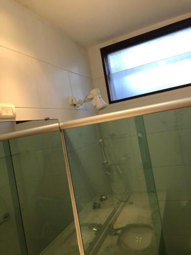 a bathroom with a glass shower with a sink at Flat 4 Suites Hotel Portal Gravata in Gravatá