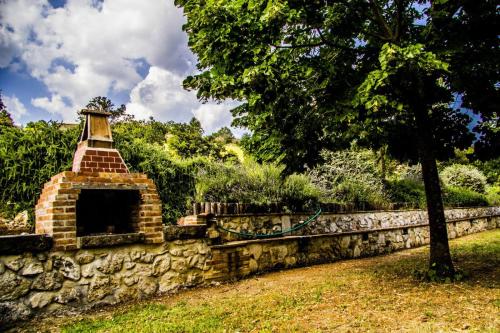 a stone wall next to a tree in a field at B&B I Montanari in Itieli