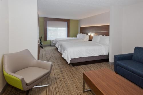 a hotel room with two beds and a chair at Holiday Inn Express Hotel & Suites Dothan North by IHG in Dothan