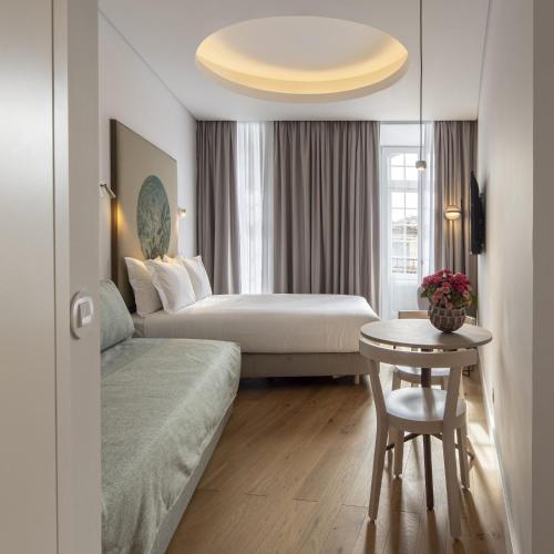 a hotel room with a bed and a table at LSA Madalena by Numa in Lisbon