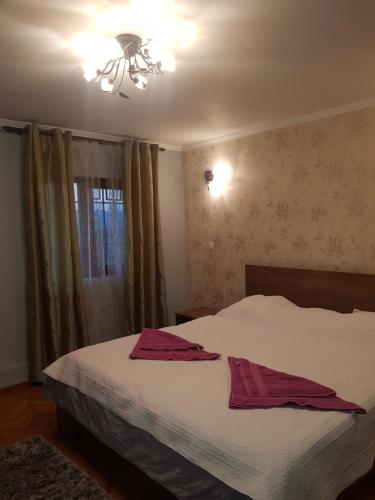 a bedroom with a bed with two towels on it at Vila Magnolia in Curtea de Argeş