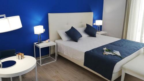 a bedroom with a bed and a blue wall at Kaloneiro Guest House in Corigliano dʼOtranto