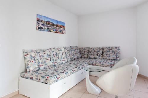 un divano bianco in una stanza con sedia bianca di Studio Bella Nissa - Welkeys a Nizza