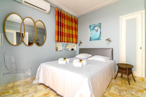 une chambre avec un lit blanc et un miroir dans l'établissement Appartement Bagatelle Exceptional location with stunning sea views, à Juan-les-Pins