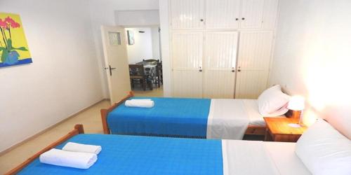 a bedroom with two beds and a dining room with a table at Maria Studios in Ayia Evfimia
