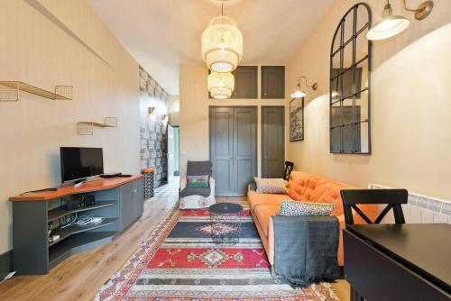 a living room with an orange couch and a tv at The Manor Suite at Moyglare House in Maynooth