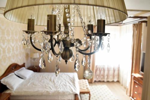 a chandelier hanging over a bed in a bedroom at Classic Residence in Poiana Brasov