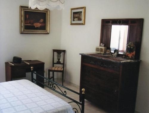 a bedroom with a bed and a dresser and a mirror at B&B I Montanari in Itieli