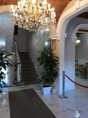 a chandelier in a building with a hallway with stairs at Hotel Paola in Altopascio