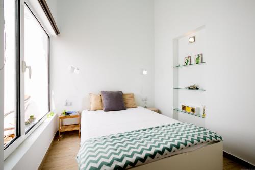 a white bedroom with a bed and a window at Cactus Apartment in San Miguel de Abona