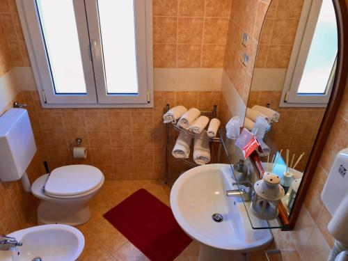 a bathroom with a toilet and a sink and a mirror at Residence Alle Scuole Country House in Granarolo dellʼEmilia
