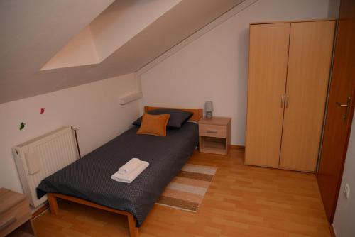 a small bedroom with a bed and a wooden cabinet at Apartmani MARIN-ŽUPANJA in Županja