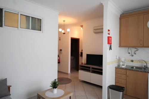 T1+1 Praia da Rocha/ Gaivota Mar 5 في بورتيماو: مطبخ وغرفة معيشة مع تلفزيون