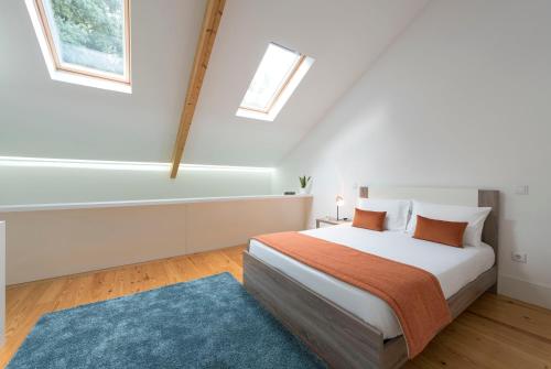 a white bedroom with a bed and a blue rug at Apartment Firehouse by Sweet Porto - Free Parking in Porto