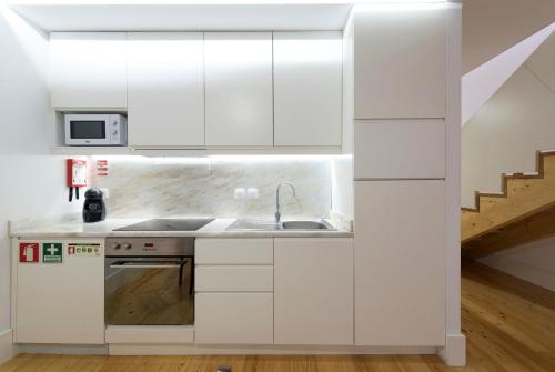 a kitchen with white cabinets and a sink at Apartment Firehouse by Sweet Porto - Free Parking in Porto