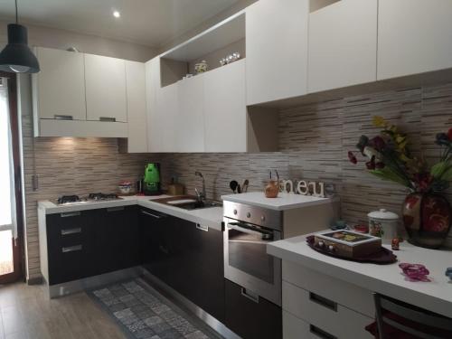 a kitchen with white cabinets and a stove top oven at Il Girasole in Basciano