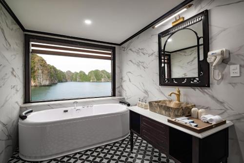 a bathroom with a tub and a sink and a window at Aspira Cruise in Ha Long