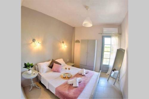 1 dormitorio con 1 cama blanca grande con almohadas rosas en Calma Luxury Apartments #2 Sozopoli in Halkidiki, en Sozopoli