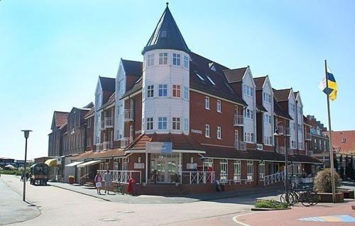 a large brown and white building with a tower at Inselresidenz Strandburg Apartment 209 in Juist