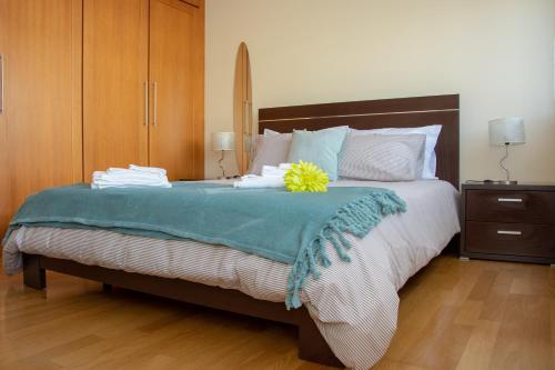 a bedroom with a bed with a yellow flower on it at Vizinha’s Dad’s Apartment in Ponta Delgada