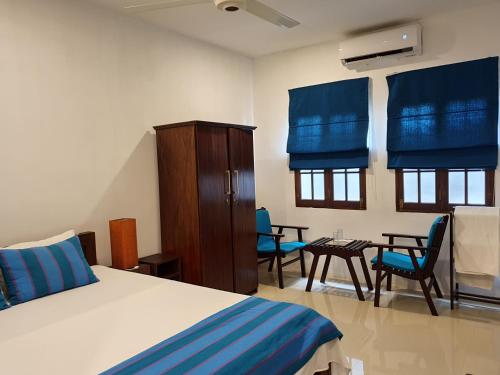 a bedroom with a bed and a table and chairs at Lohas Beach Resort Villa in Kalutara