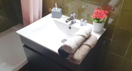 - un lavabo blanc dans la salle de bains avec des serviettes dans l'établissement Fantástico apartamento al lado del Serrallo, à Tarragone