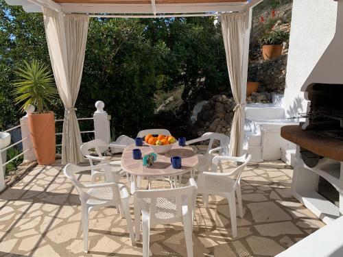 a table and chairs on a patio with a bowl of oranges at Villa Montesolana in Pedreguer