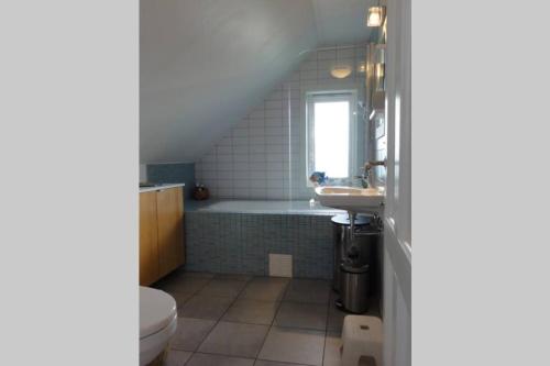 a bathroom with a tub and a sink and a toilet at Charming flat in cosy farmhouse in Skudeneshavn