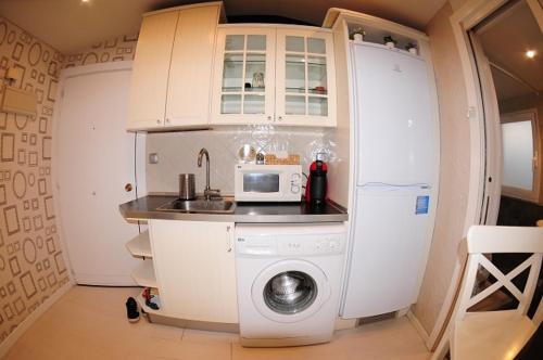 a small kitchen with a washing machine and a microwave at APARTAMENTOS URDAIBAI 5 in Bermeo