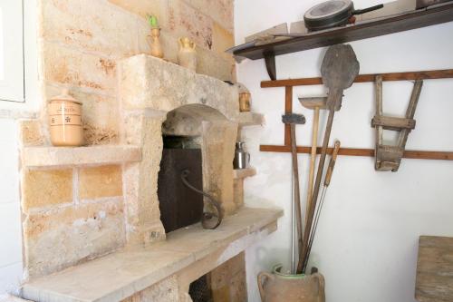 una chimenea de piedra en una sala de estar con un estante en Masseria Nanni, en Gallipoli