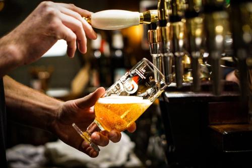 a person is holding a glass of beer at Harbour Living by Jutlandia - Hostel Style in Frederikshavn