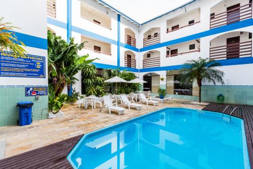 a hotel with a swimming pool in front of a building at HsHotelaria - Filial Bombinhas in Bombinhas