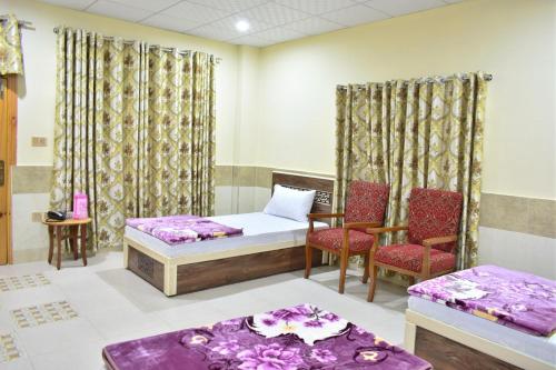 a room with two beds and two chairs at SWAT GUEST HOUSE in Mingora
